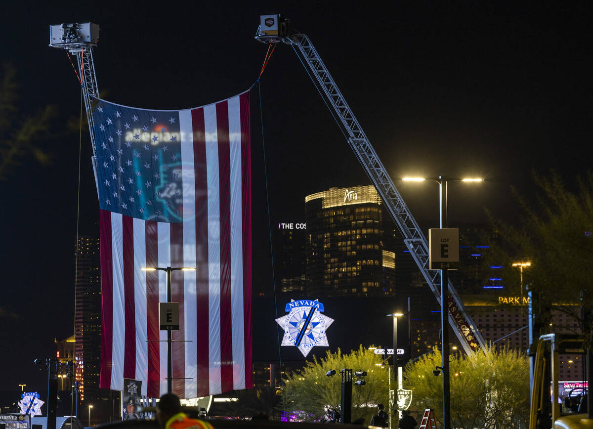 A large American flag is suspended from firetrucks dedicated to Nevada Highway Patrol troopers ...