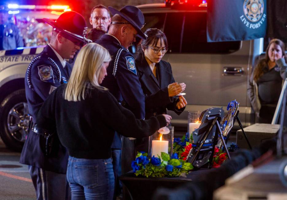 Trooper's wives Vanessa Abbate and Arlene Felix light candles during a candlelight vigil for Ne ...