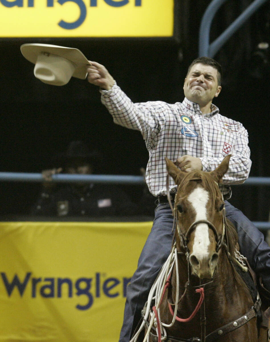 Professional calf roper Cody Ohl throws his hat after making a second place time in the Tie-dow ...