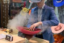 A cowboy hat shaper plies his trade from one of the hundreds of vendor booths at The Cowboy Cha ...