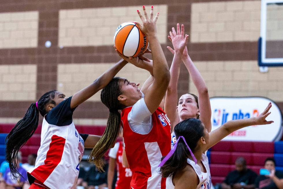 Nation Williams (44), center, is fouled on a shot by Qandace Samuels (20) during a Jr.NBA show ...