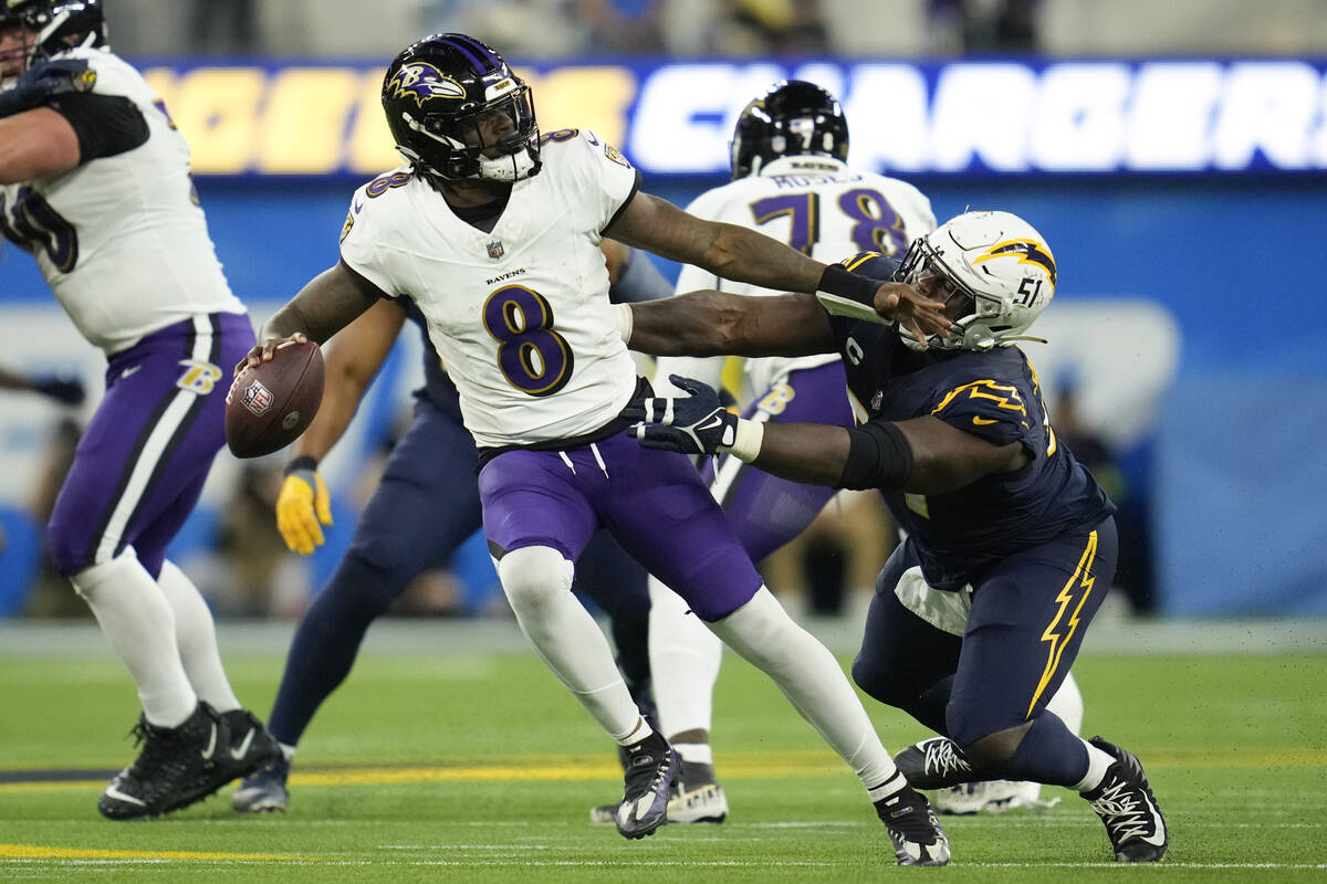 Baltimore Ravens quarterback Lamar Jackson (8) is tackled by Los Angeles Chargers defensive tac ...
