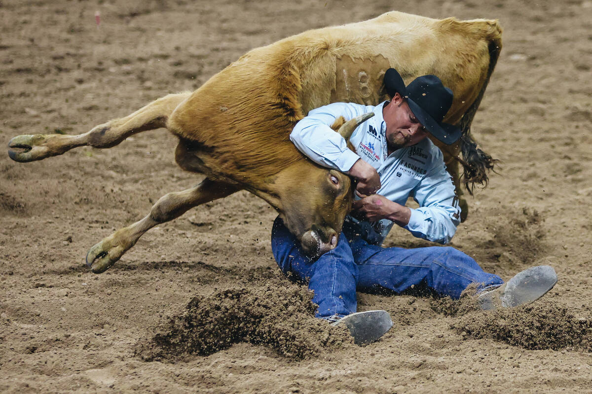 Stan Branco wrestles his steer during steer wrestling at the National Finals Rodeo in the Thoma ...