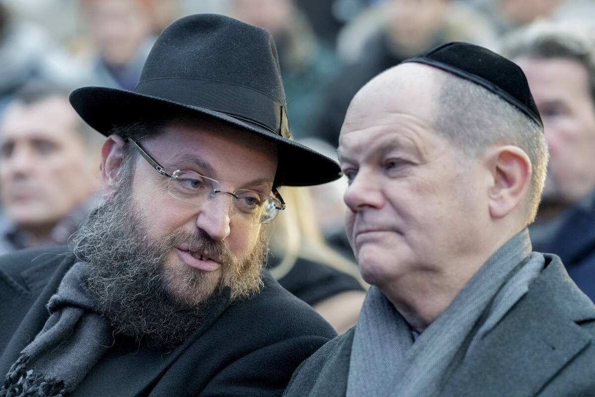 German Chancellor Olaf Scholz, right, and Rabbi Yehuda Teichtal attend the ceremony to light th ...