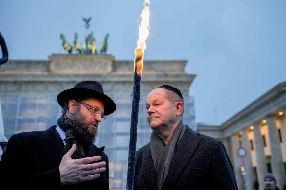 German Chancellor Olaf Scholz, right, and Rabbi Yehuda Teichtal attend the ceremony to light th ...