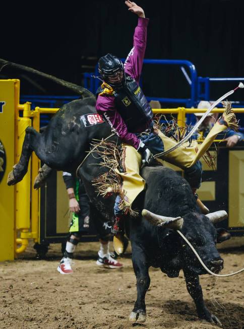 Jared Parsonage rides the bull during day three of the National Finals Rodeo at the Thomas &amp ...