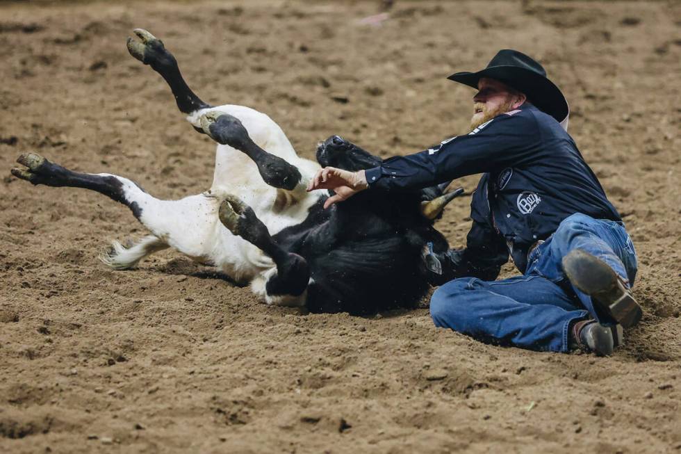 Will Lummus wrestles the steer during steer wrestling on day three of the National Finals Rodeo ...