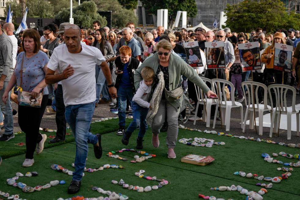 Israelis rush to a shelter as a siren sounds a warning of incoming rockets fired from the Gaza ...