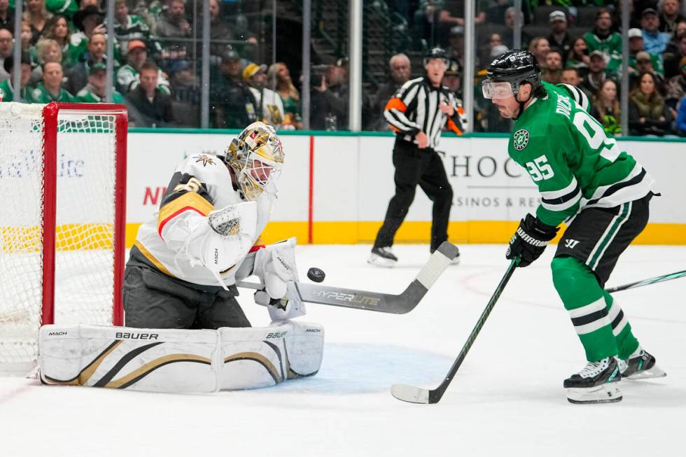 Vegas Golden Knights goaltender Logan Thompson, left, makes a save as Dallas Stars center Matt ...