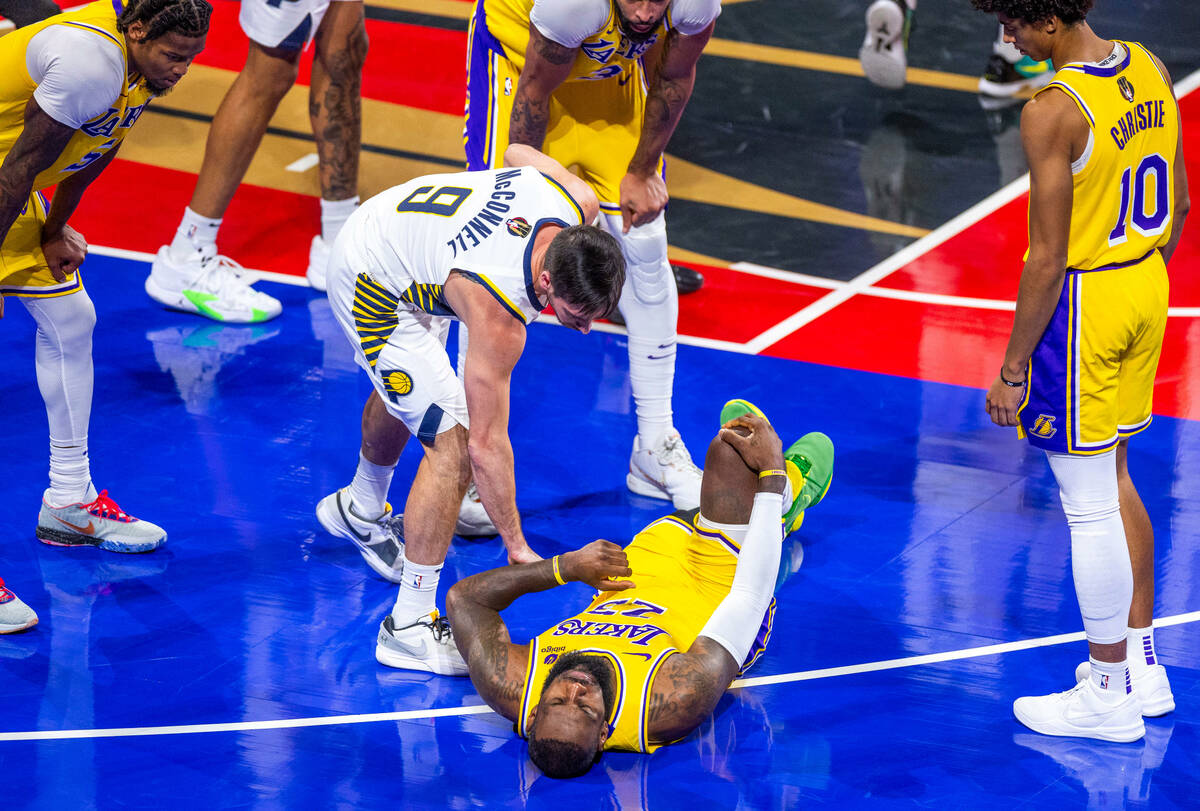 Los Angeles Lakers forward LeBron James (23) grabs his knee after a collision with Indiana Pace ...