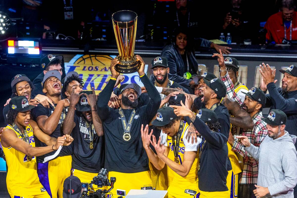 Los Angeles Lakers forward LeBron James (23) holds up the winning trophy about teammates after ...