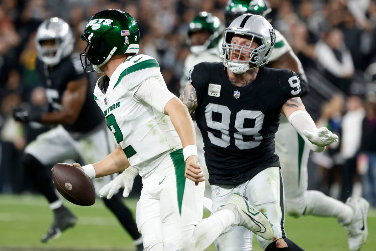 New York Jets quarterback Zach Wilson (2) is chased by Raiders defensive end Maxx Crosby (98) d ...