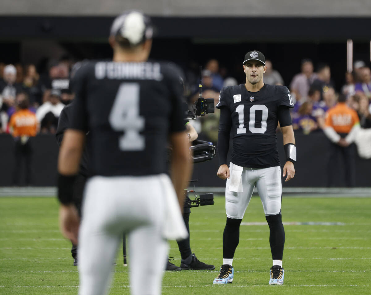 Raiders quarterbacks Aidan O'Connell (4) and Jimmy Garoppolo (10) warm up before the start of a ...