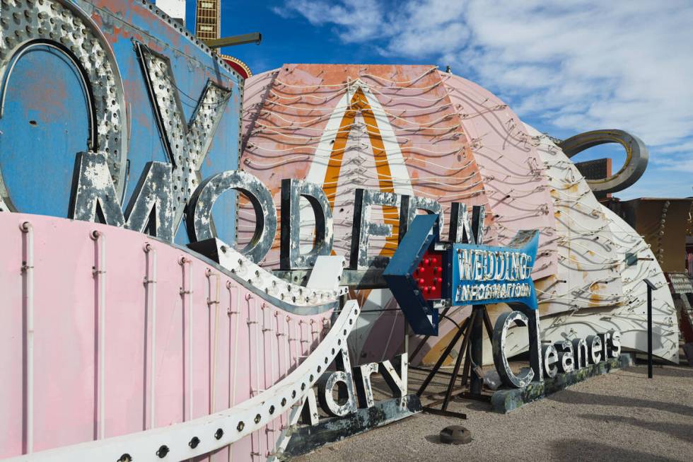 The 1967 pylon Flamingo sign, center, and one of the 1976 feather plume signs, left, that will ...