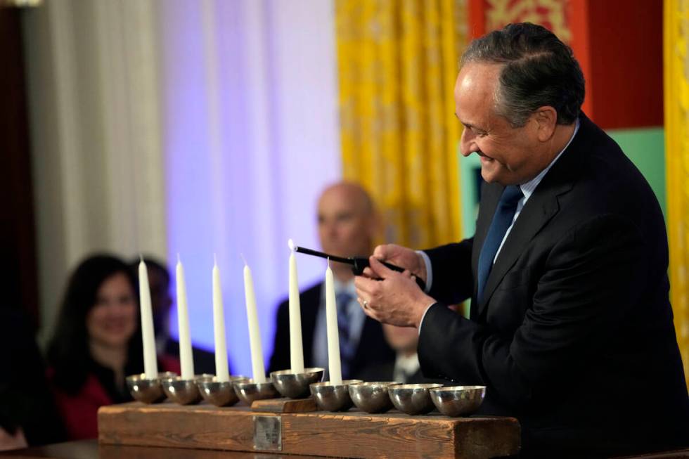 Second gentleman Doug Emhoff lights the Shamash on menorah during a Hanukkah reception with Pre ...