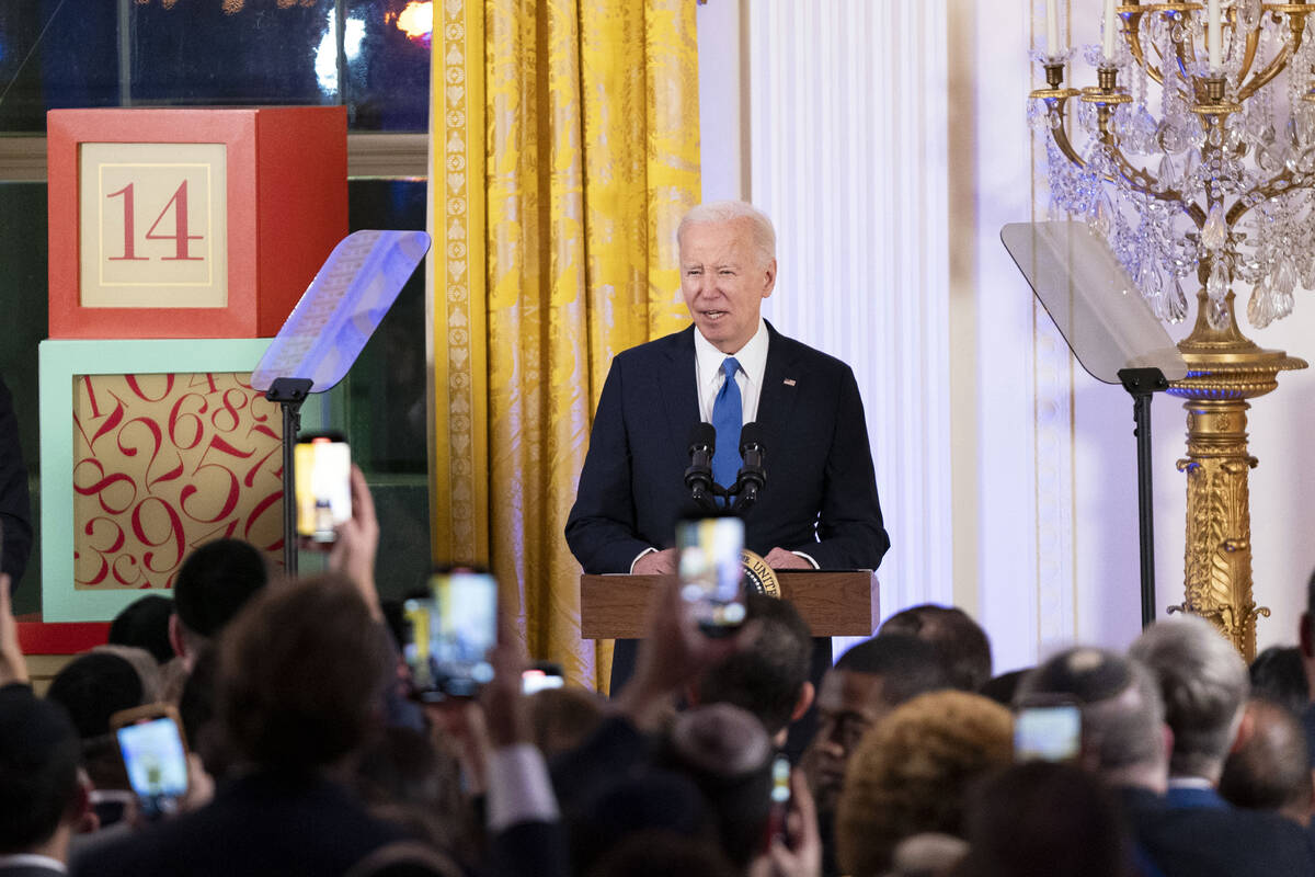 President Joe Biden speaks at a Hanukkah reception in the East Room of the White House in Washi ...