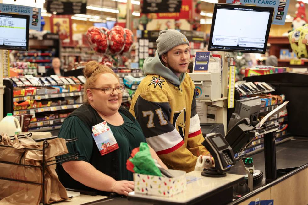 Golden Knights center William Karlsson helps customers check out at a Smith's on Monday during ...