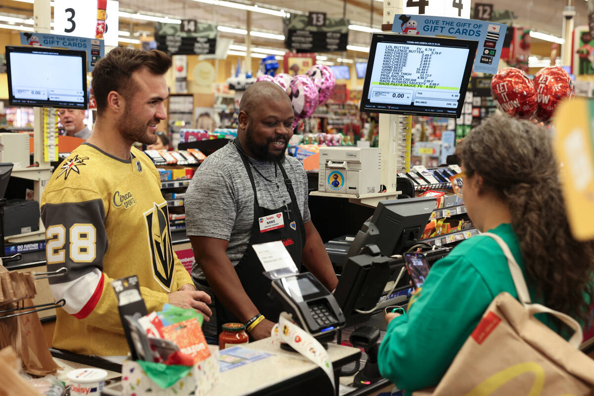 Golden Knights left wing William Carrier helps customers check out at a Smith's on Monday durin ...