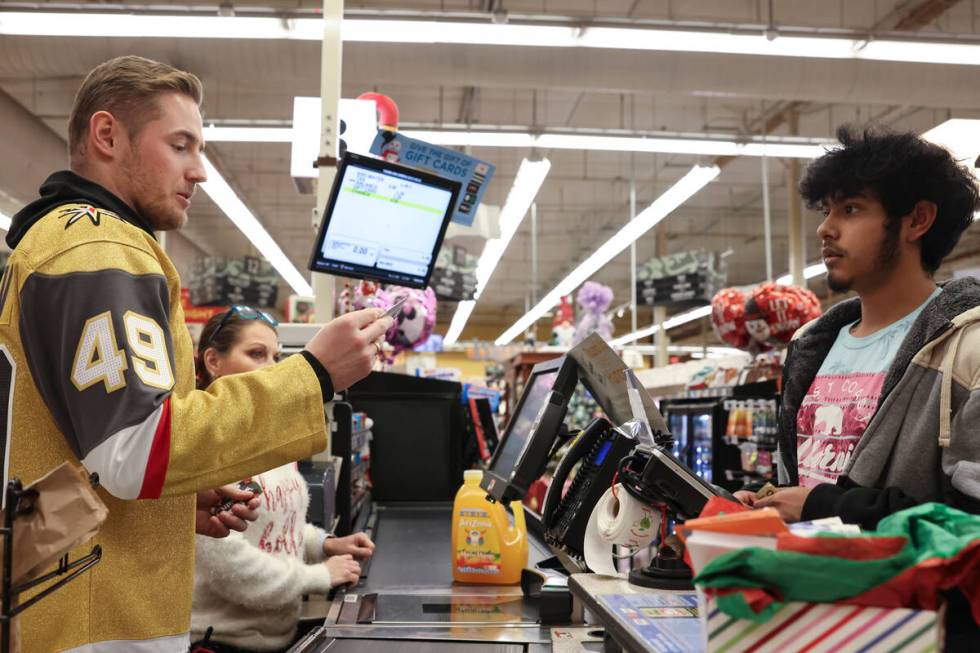 Golden Knights left wing Ivan Barbashev helps customers check out at a Smith's on Monday during ...