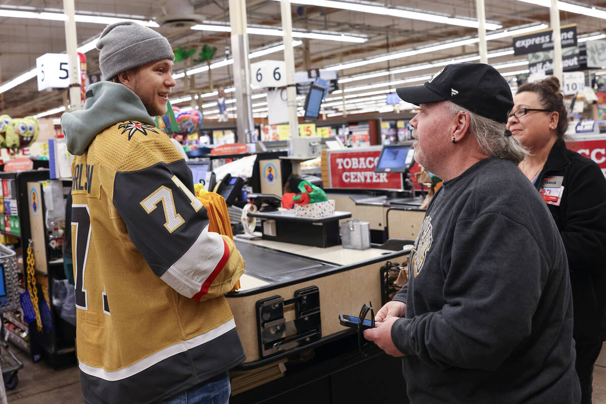 Golden Knights center William Karlsson helps customers check out at a Smith's on Monday during ...