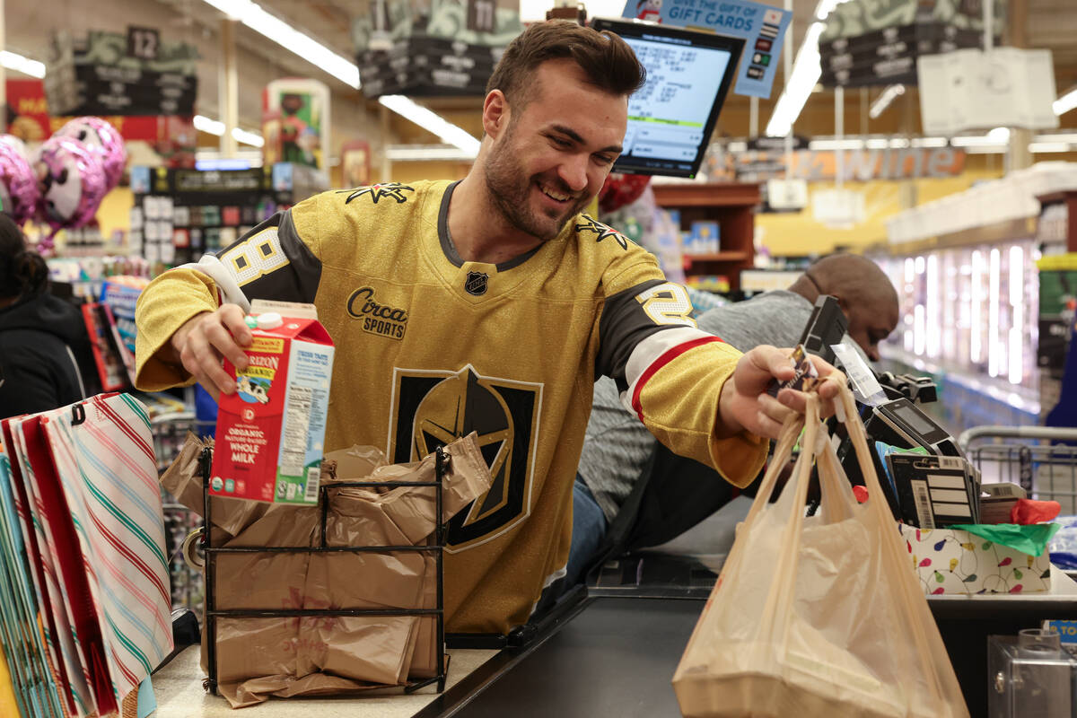 Golden Knights left wing William Carrier helps customers check out at a Smith's on Monday durin ...