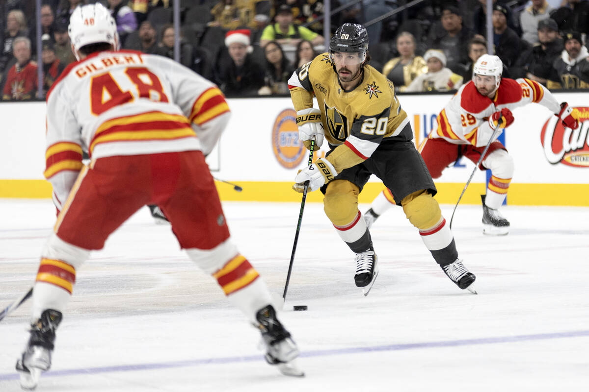 Golden Knights center Chandler Stephenson (20) skates with the puck against Flames defenseman D ...