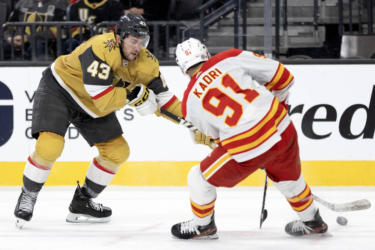 Golden Knights center Paul Cotter (43) battles for the buck with Flames center Nazem Kadri (91) ...