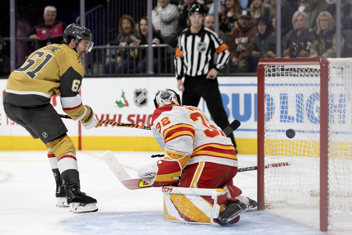 Golden Knights right wing Mark Stone (61) scores on Flames goaltender Dustin Wolf (32) during t ...