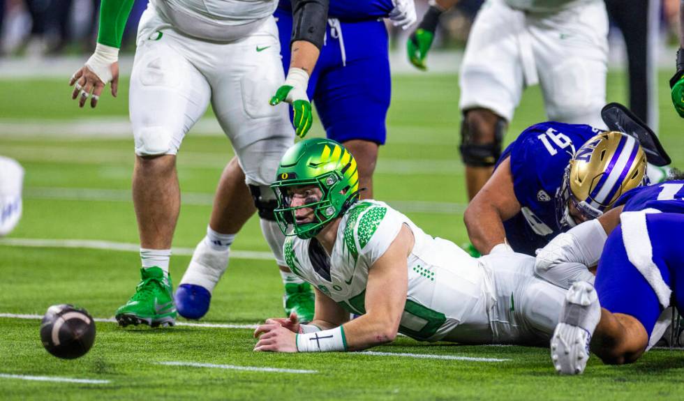 Oregon Ducks quarterback Bo Nix (10) looks to a loose ball on a run after a tackle by Washingto ...