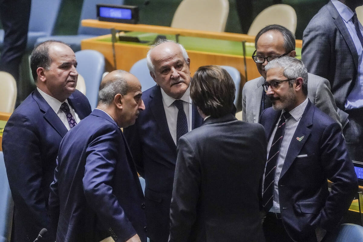 Palestinian United Nations Ambassador Riyad Mansour, third from left, confer with diplomats bef ...