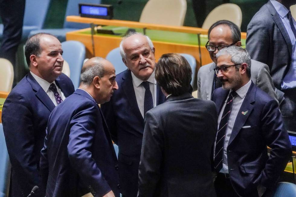 Palestinian United Nations Ambassador Riyad Mansour, third from left, confer with diplomats bef ...