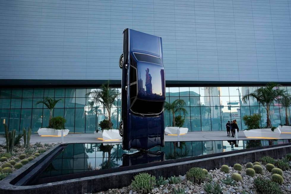 People stand beside the sculpture titled History of Suspended Time at an entrance to the Fontai ...