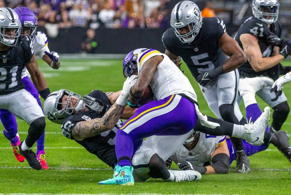 Raiders defensive end Maxx Crosby (98) stops Minnesota Vikings running back Alexander Mattison ...