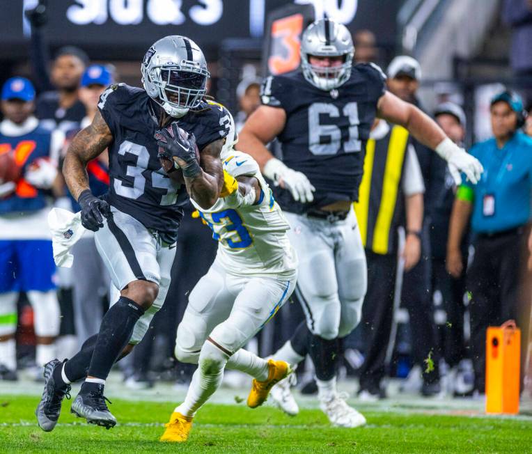 Raiders running back Brandon Bolden (34) runs for a touchdown past Los Angeles Chargers cornerb ...