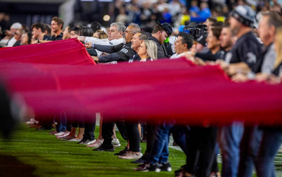 The American flag is waved on the field for the National Anthem before the first half of the Ra ...