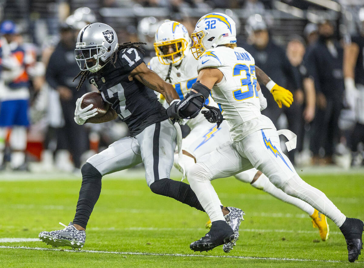 Raiders wide receiver Davante Adams (17) runs after a catch as Los Angeles Chargers safety Aloh ...