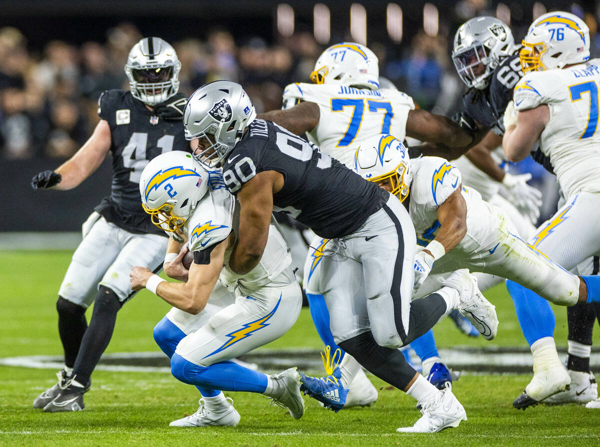 Los Angeles Chargers quarterback Easton Stick (2) is sacked by Raiders defensive tackle Jerry T ...