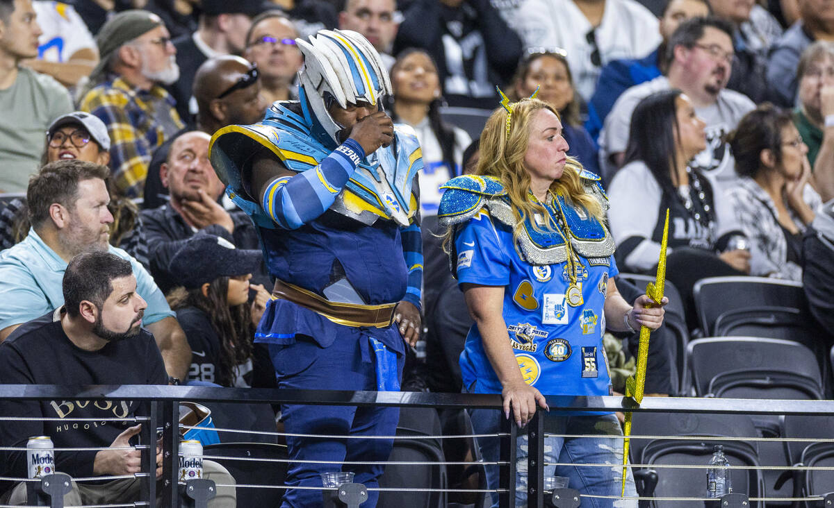 Several Los Angeles Chargers fans stand dejected as the Raiders dominate during the first half ...