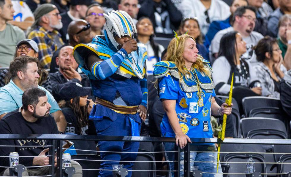 Several Los Angeles Chargers fans stand dejected as the Raiders dominate during the first half ...