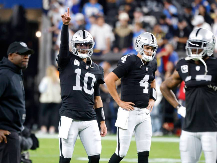 Raiders quarterback Jimmy Garoppolo (10) points high as quarterback Aidan O'Connell (4) looks o ...