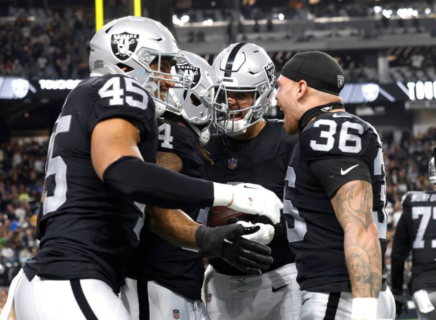 Raiders running back Brandon Bolden (34) celebrates his touchdown with teammates, including ful ...