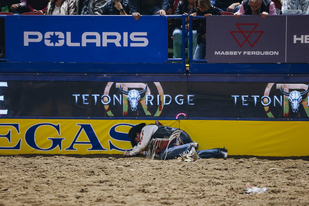 Layton Green lays on the ground after falling off of the horse during the saddle bronc portion ...