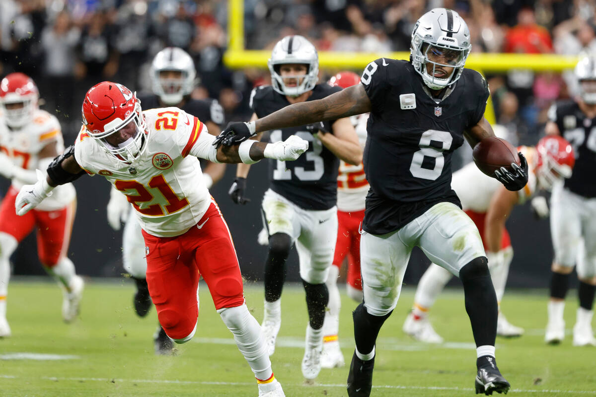 Raiders running back Josh Jacobs (8) pushes Kansas City Chiefs safety Mike Edwards (21) away as ...