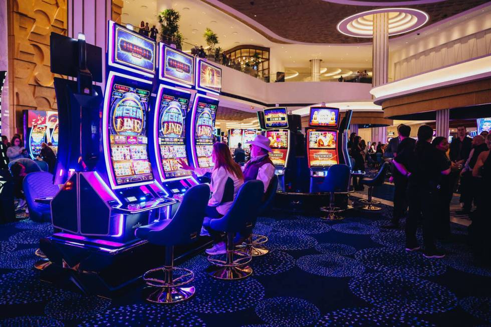 People play on the slot machines during the Fontainebleau’s grand opening to the public ...