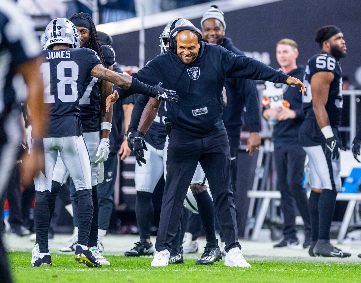 Raiders interim head coach Antonio Pierce celebrates an interception and touchdown with cornerb ...