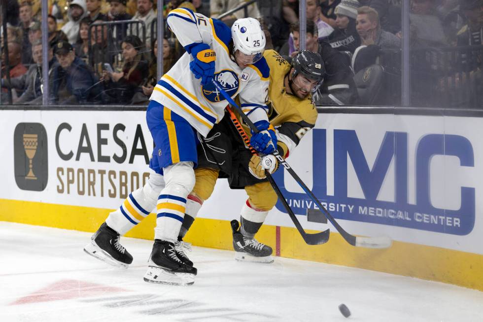 Golden Knights left wing William Carrier (28) battles for the puck against Sabres defenseman Ow ...