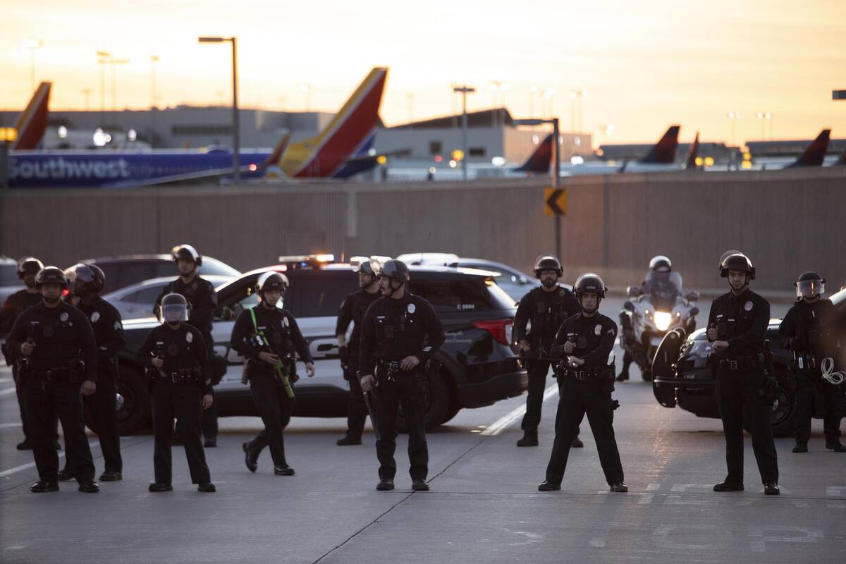 Police hold the line, preventing members of CeaseFireLA to march into the Los Angeles Internati ...