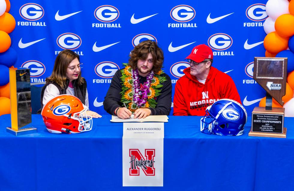 Bishop Gorman player Alexander Ruggeroli and family with a commitment letter to the University ...
