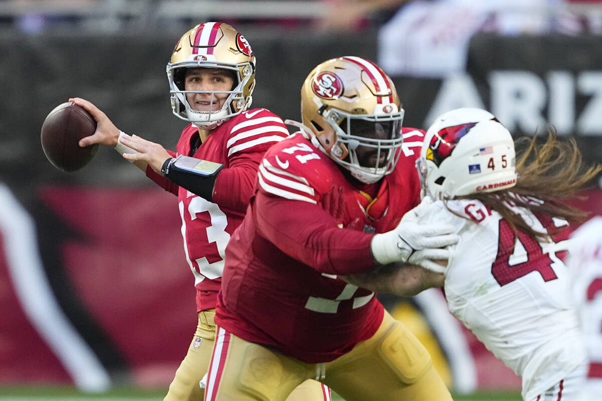 San Francisco 49ers quarterback Brock Purdy (13) passes as offensive tackle Trent Williams bloc ...