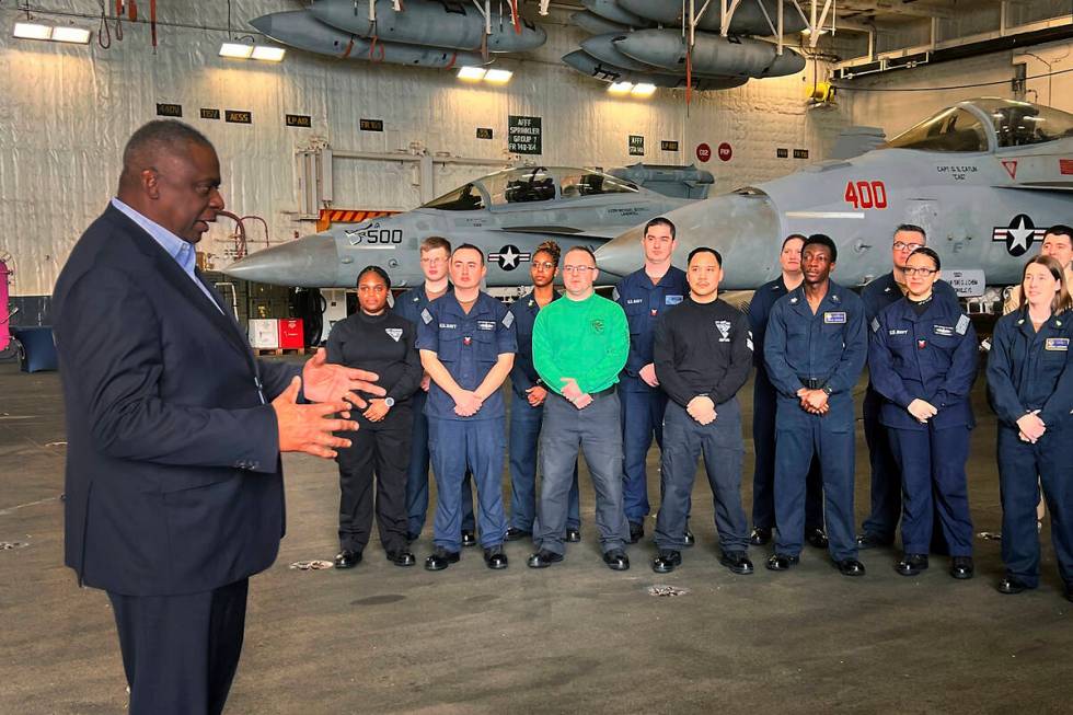Defense Secretary Lloyd Austin, left, talks to crew members of the USS Gerald R. Ford during an ...